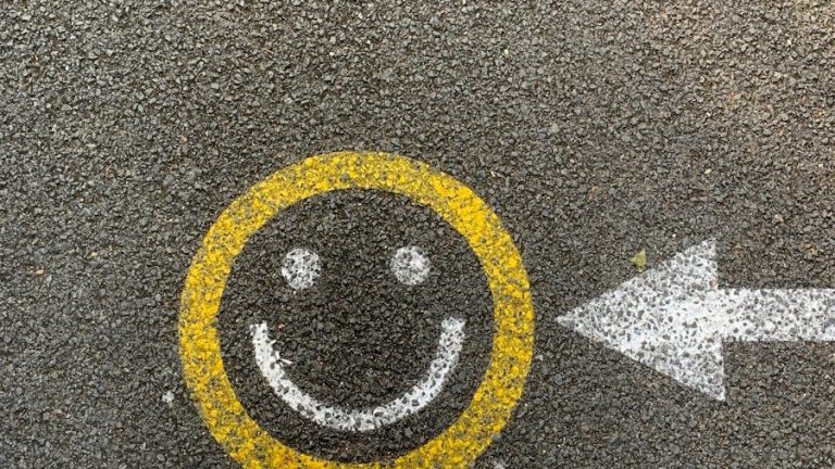 person in white shoes standing on gray concrete road