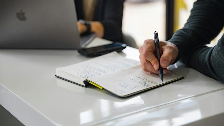 person writing on white paper